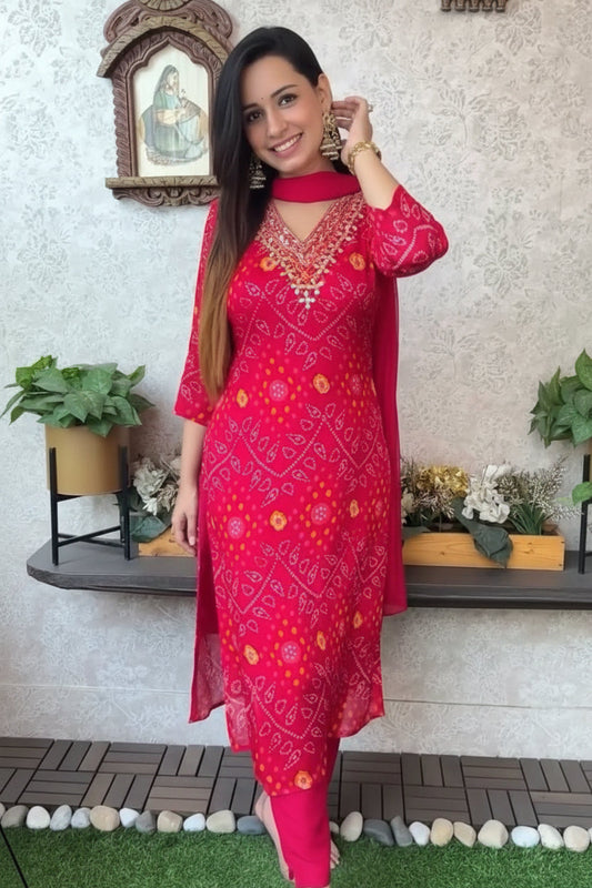 Woman wearing a red and pink traditional outfit with a decorative background
