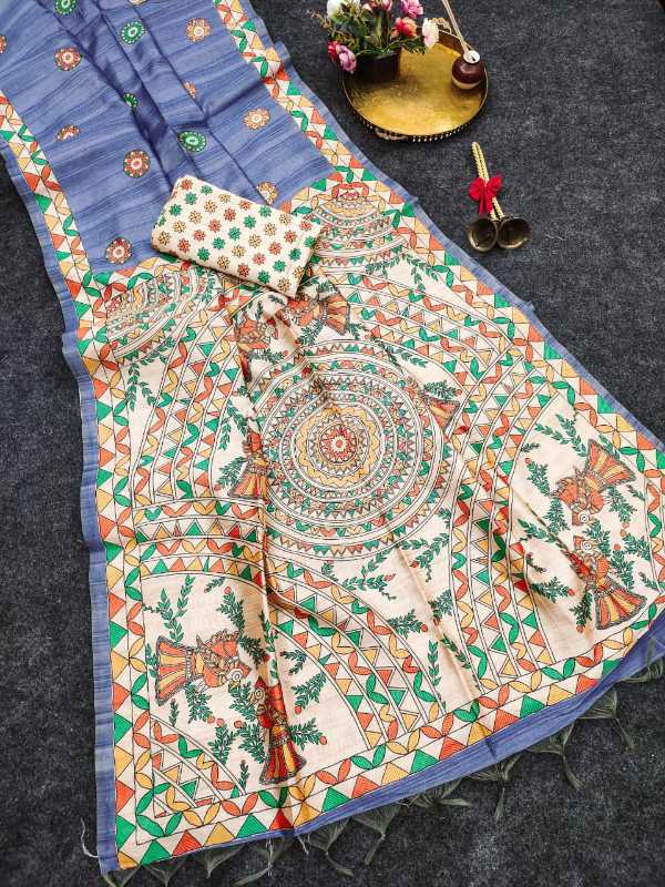 A traditional Indian salwar suit set laid out on a dark gray textured surface, featuring a blue base fabric with a large cream-colored printed skirt decorated with intricate mandala and floral motifs, along with a matching pocket square.