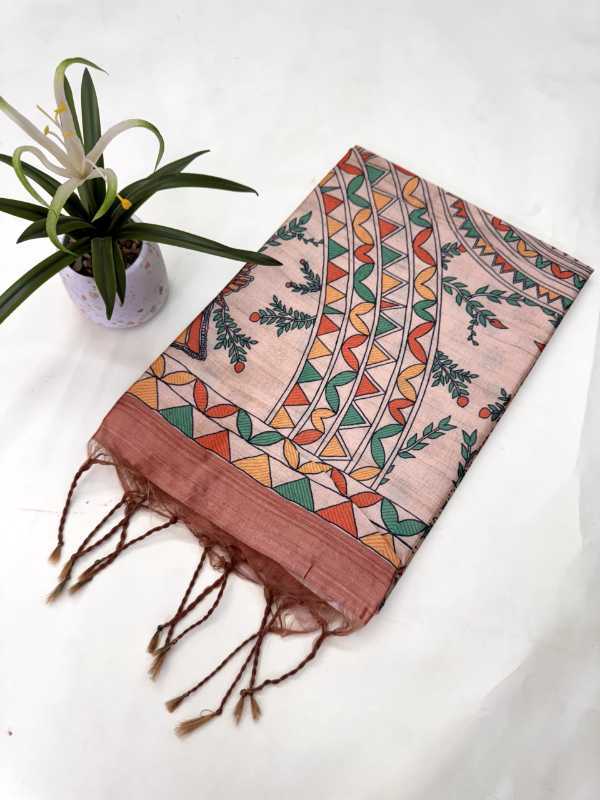 Decorative scarf with geometric pattern on a white surface next to a plant