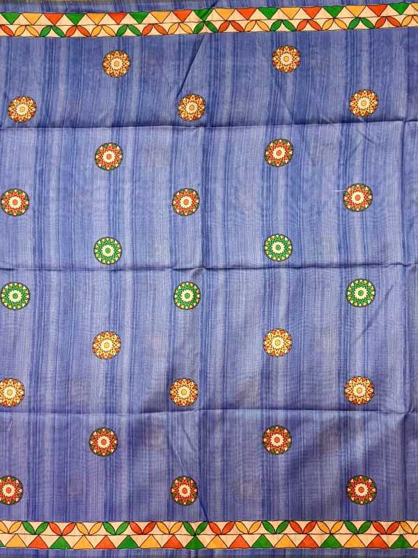 A blue woven fabric, likely a saree or scarf, featuring vertical stripes and a border of orange, green, and yellow geometric patterns. The body of the fabric is decorated with rows of circular motifs in orange, yellow, and green.