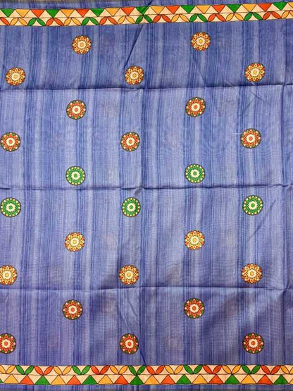 A blue woven fabric, likely a saree or scarf, featuring vertical stripes and a border of orange, green, and yellow geometric patterns. The body of the fabric is decorated with rows of circular motifs in orange, yellow, and green.