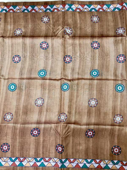 A brown woven fabric, likely a saree or scarf, featuring a vertical striped texture and a repeating pattern of colorful circular medallions. The fabric is finished with geometric borders at the top and bottom in red, blue, green, and white.