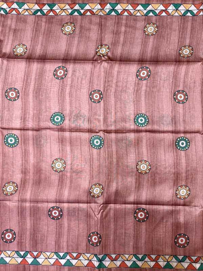A dusty rose pink fabric, likely a saree, featuring a subtle vertical stripe texture and decorated with small circular mandala motifs in green, gold, and white. The fabric is finished with a colorful geometric border pattern at the top and bottom.