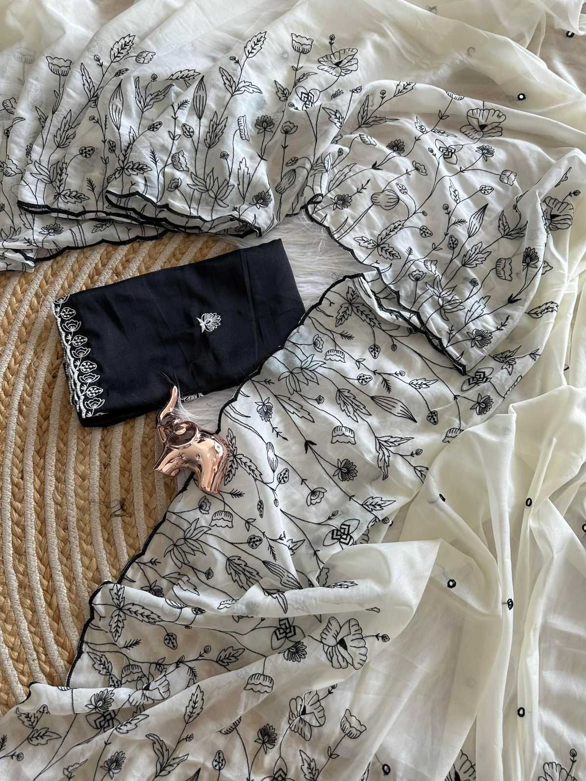 Black clutch bag with floral design on a white fabric background