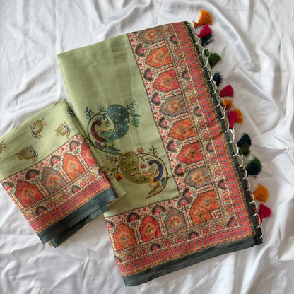 Decorative green fabric with intricate patterns and tassels on a white background