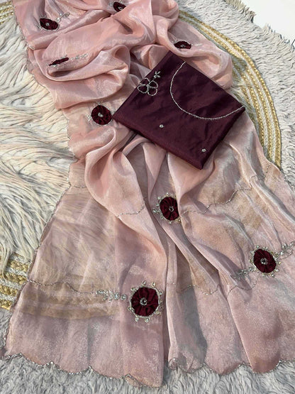 A draped light pink organza dupatta with silver mirror work and maroon floral embellishments, paired with a matching maroon blouse piece on a textured white rug.