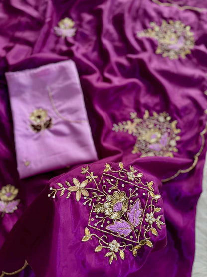 Purple and lavender silk fabric with intricate gold floral embroidery, featuring a matching folded fabric piece with a central gold applique.