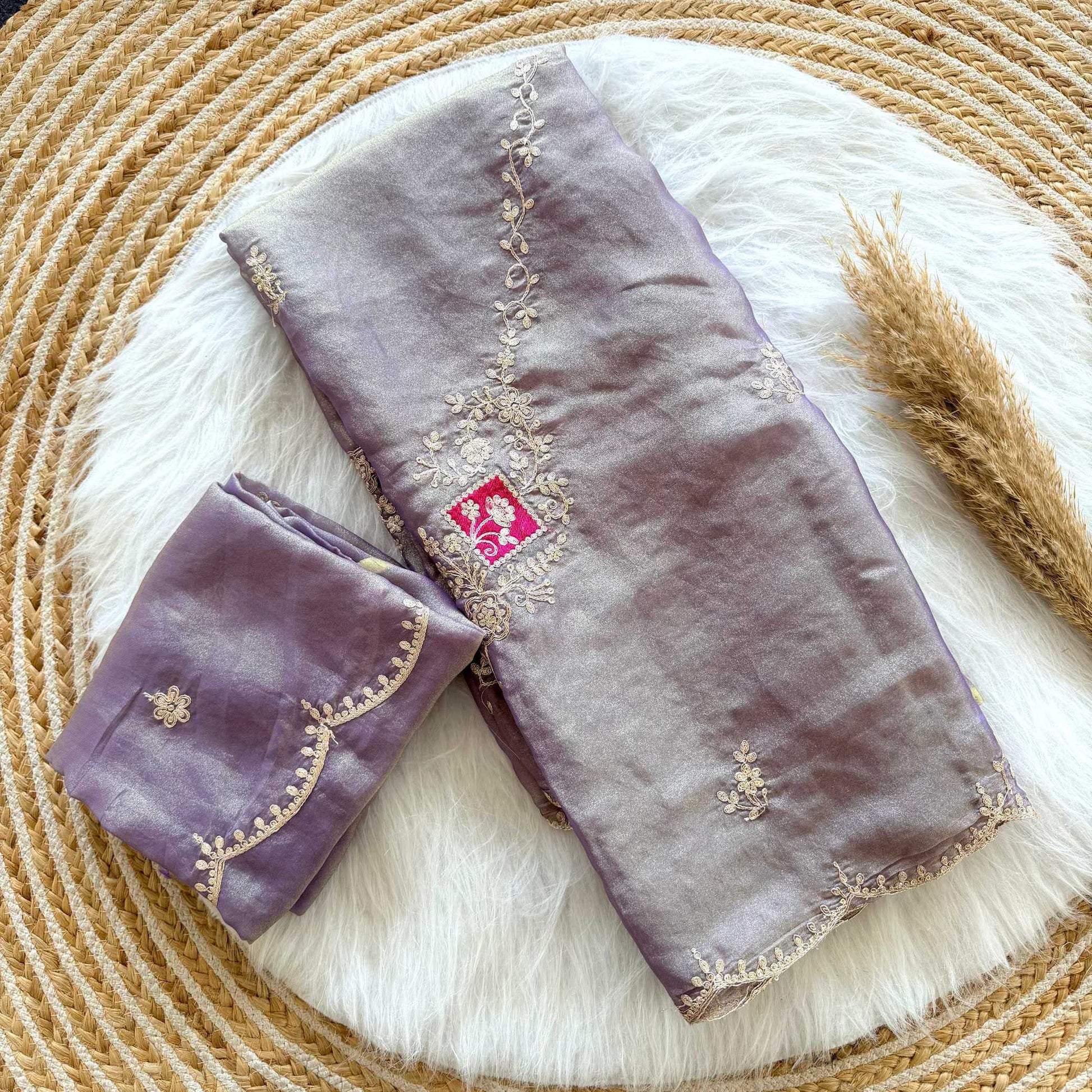 Purple fabric with gold embroidery on a textured surface