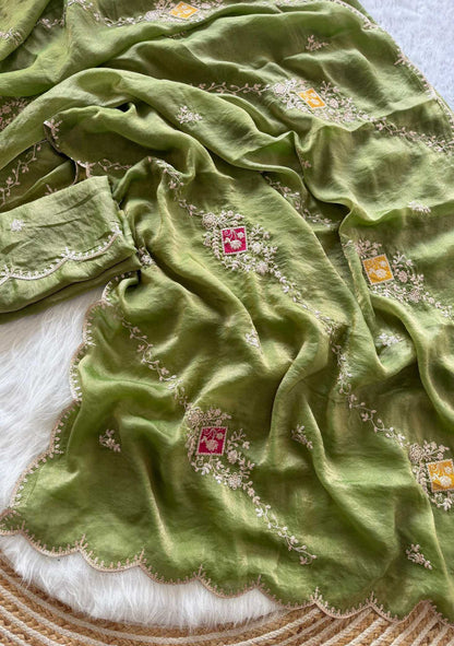 Green fabric with floral embroidery on a textured surface