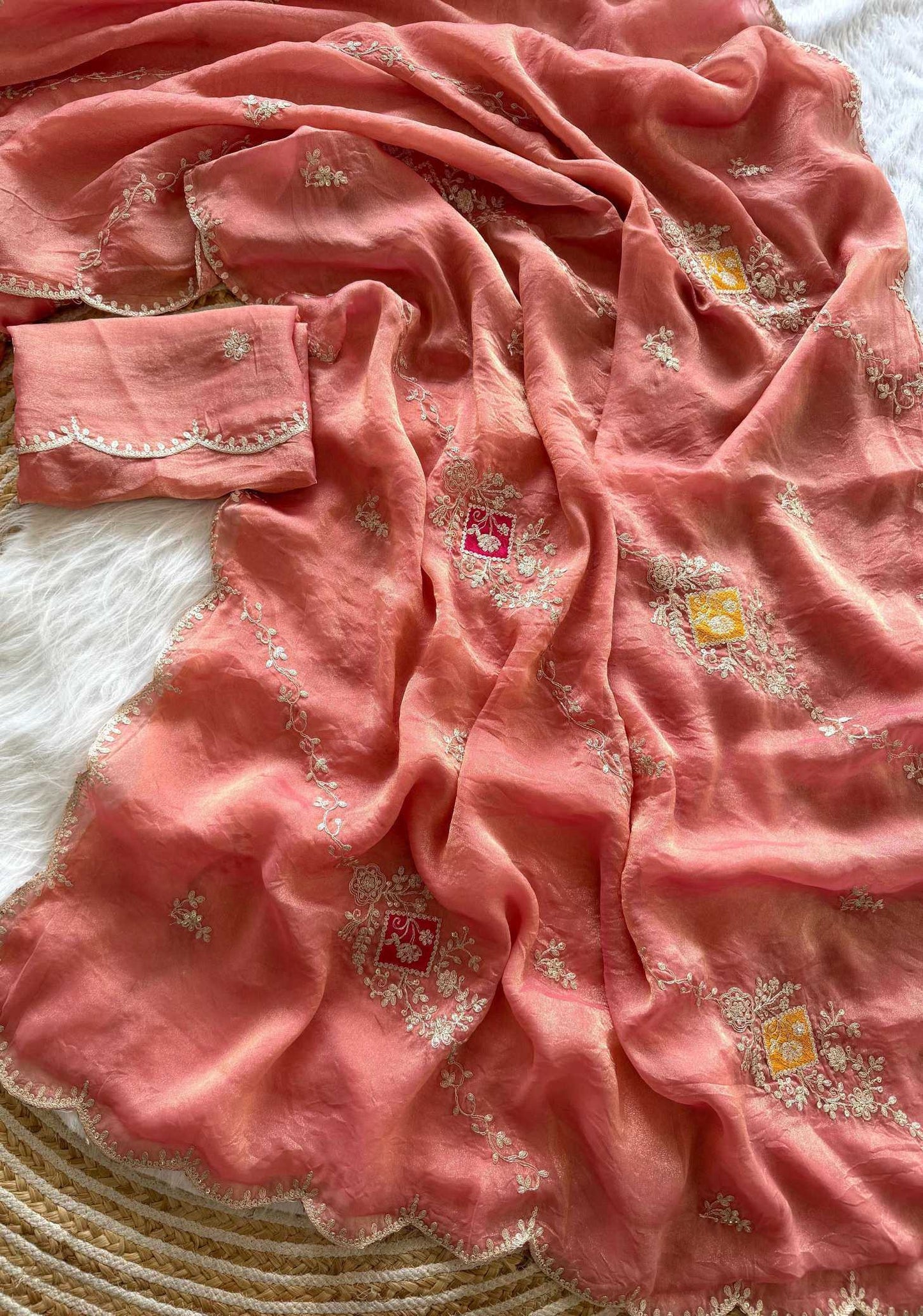 Pink saree with intricate patterns on a textured surface