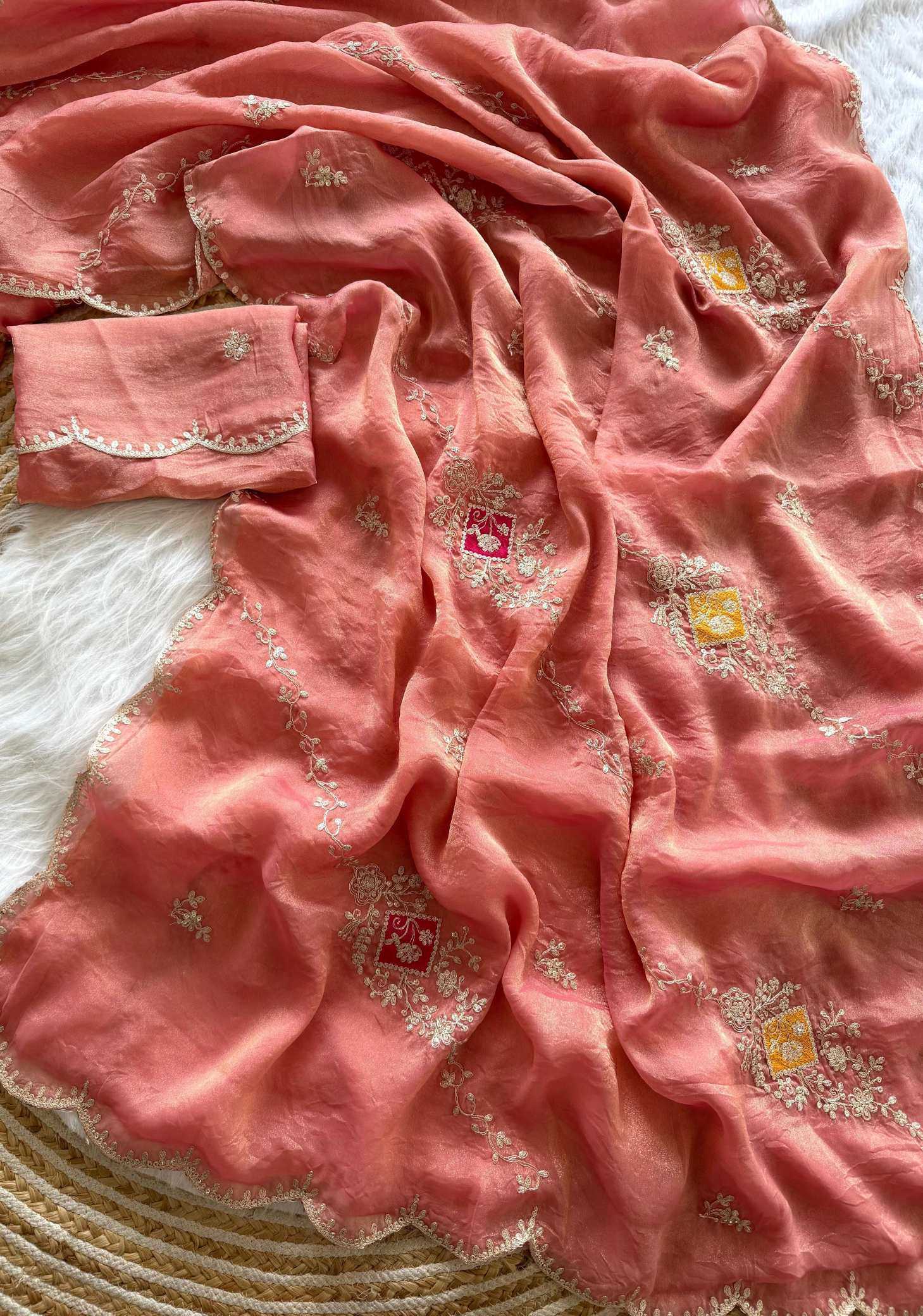 Pink saree with intricate patterns on a textured surface