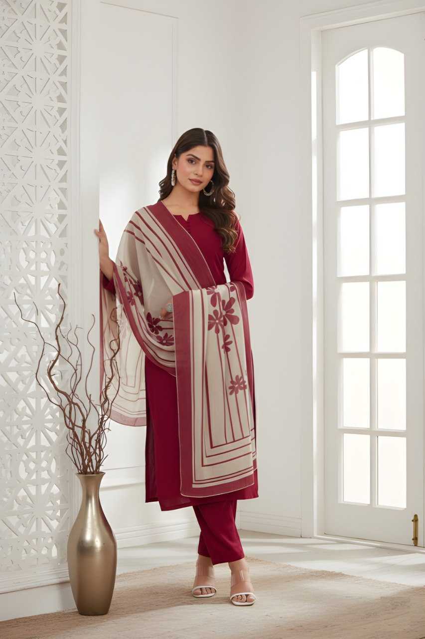 Woman in a red traditional outfit with a white dupatta in a bright room.