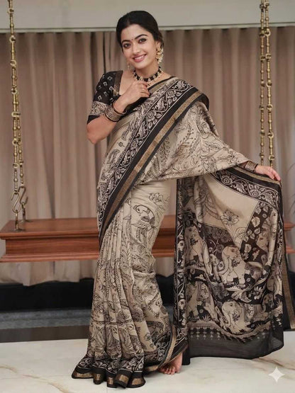 Woman wearing a traditional saree with intricate patterns in a room setting.