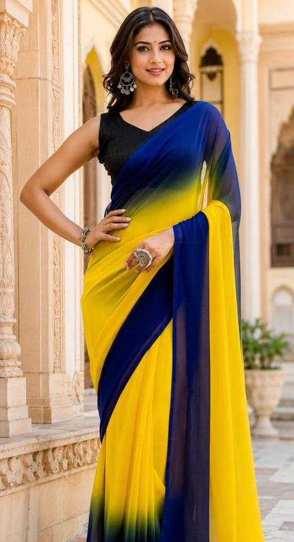 Woman wearing a yellow and blue saree in front of an architectural background
