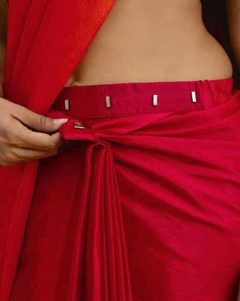 Red garment with a belt being adjusted, focusing on the waist area.