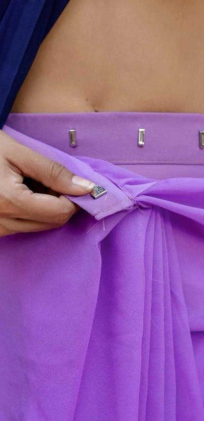 Close-up of a person adjusting a purple garment with metallic buttons.