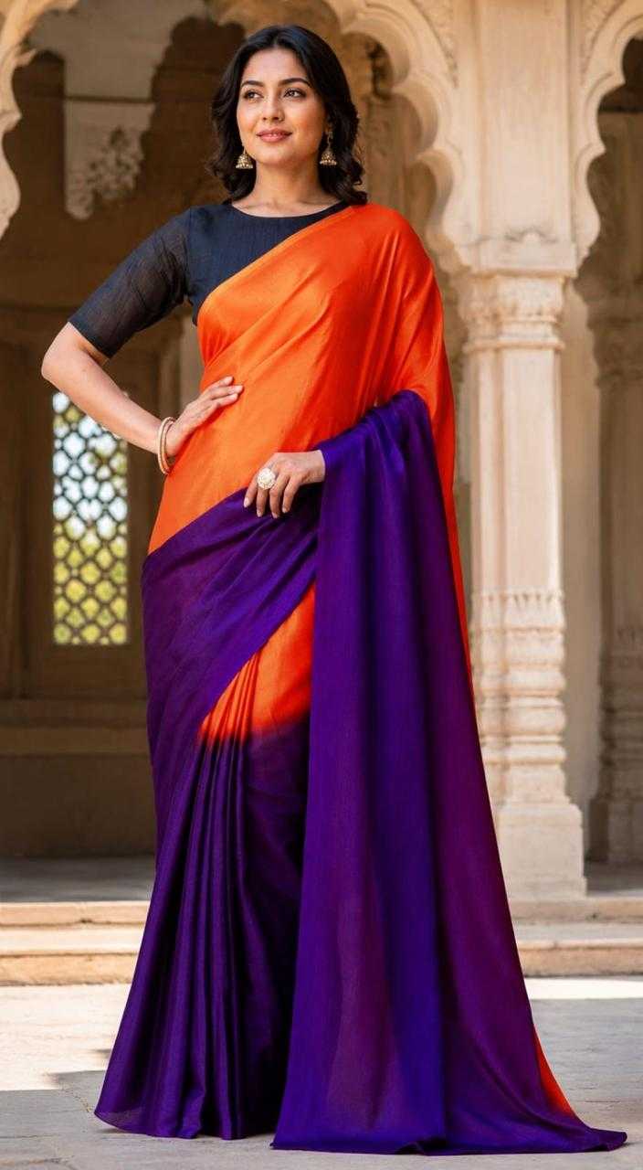 Woman wearing an orange and purple saree in front of architectural background