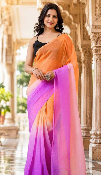 Woman wearing an orange and pink saree in a decorative setting