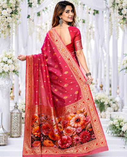 Woman wearing a red saree with floral patterns in a decorated indoor setting