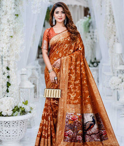 Woman wearing a brown saree with a floral pattern in a decorated indoor setting.