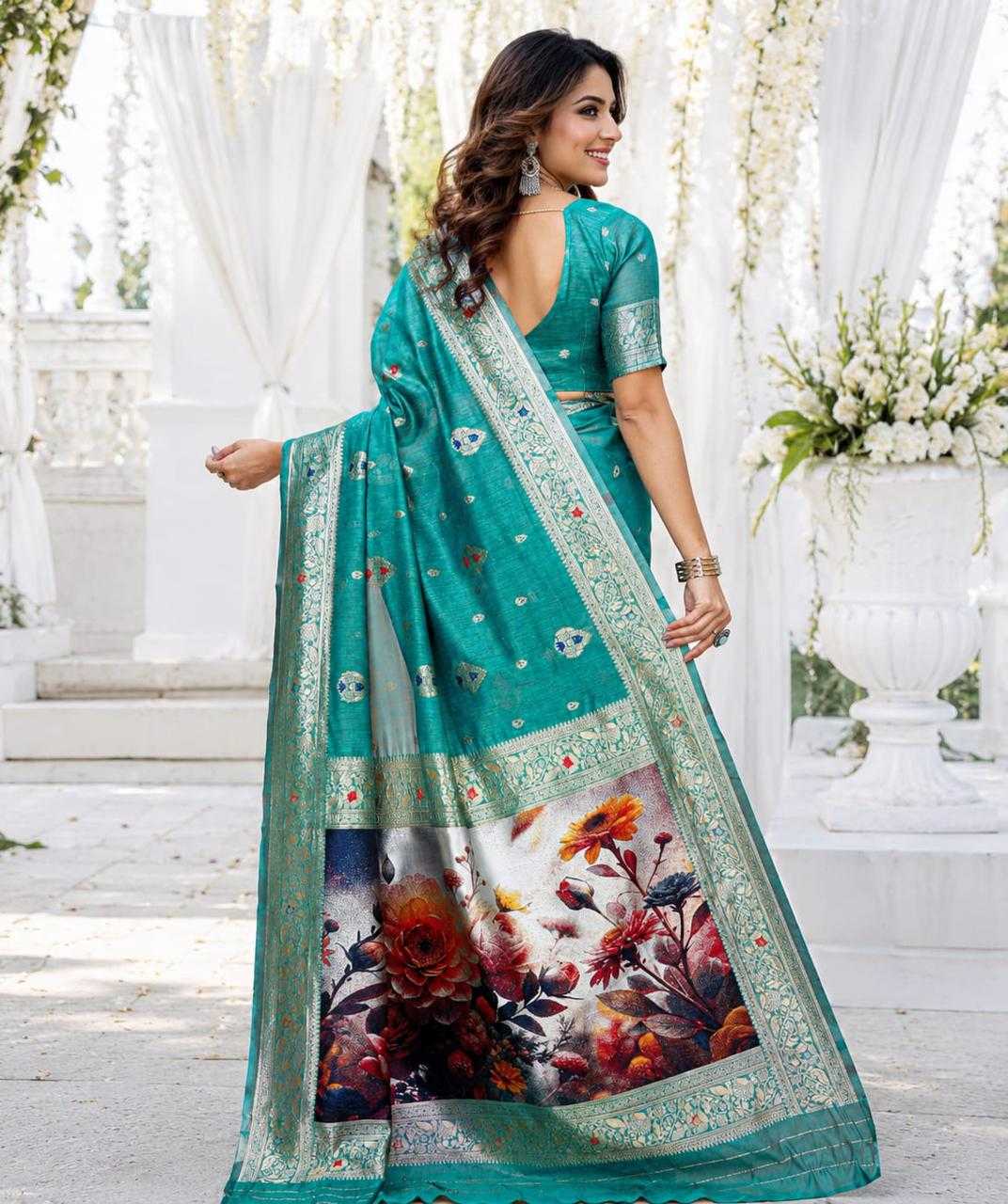 Woman wearing a teal saree with floral patterns in an outdoor setting.
