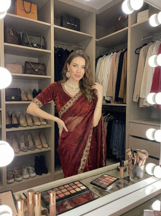 Woman in a red saree standing in a well-lit wardrobe with shelves of shoes and bags.