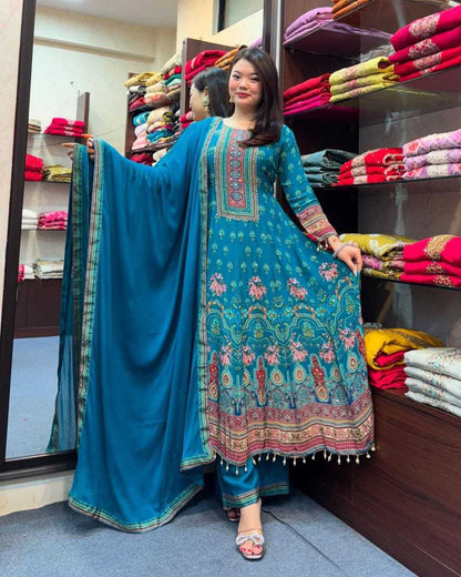 Woman in a blue embroidered traditional outfit standing in a fabric store.