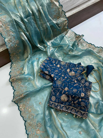 Blue embroidered fabric with gold detailing on a light blue fabric background