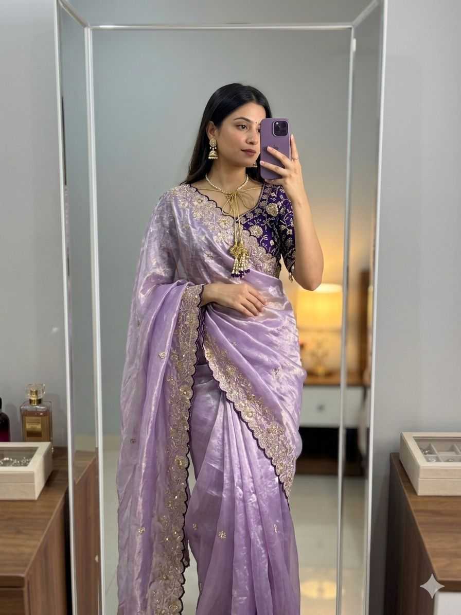 Woman wearing a lavender saree with gold embroidery in front of a mirror.