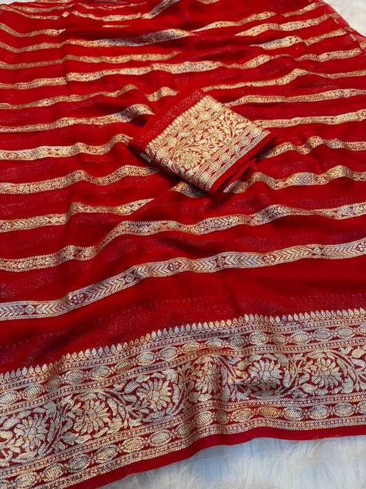 A red Banarasi silk saree with intricate gold zari woven patterns and borders, with a matching folded fabric piece placed on top.