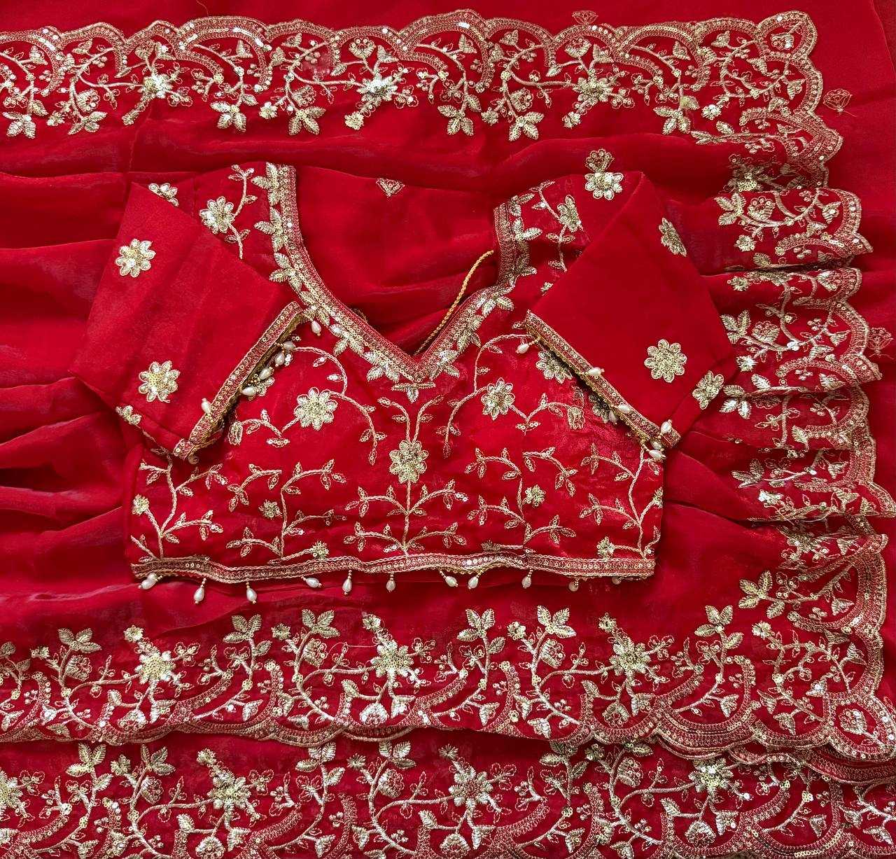 Red embroidered blouse with gold detailing on a red fabric background