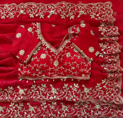 Red embroidered blouse with gold detailing on a red fabric background