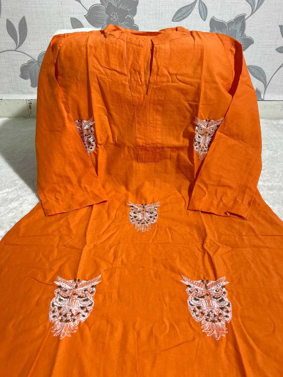 Orange kurta with floral embroidery on a light gray background