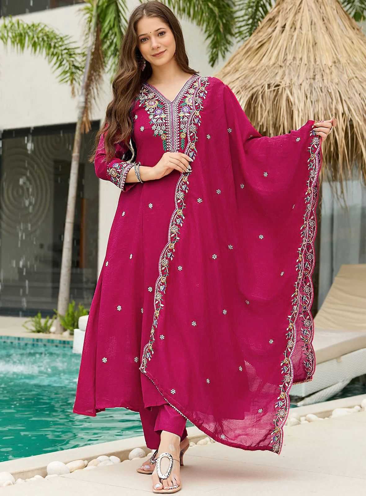 Woman in a pink traditional outfit standing by a poolside.