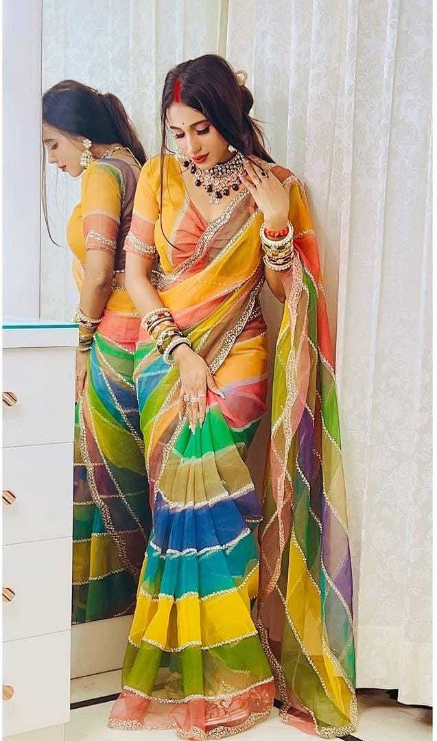 Woman wearing a colorful saree with a mirror reflection.