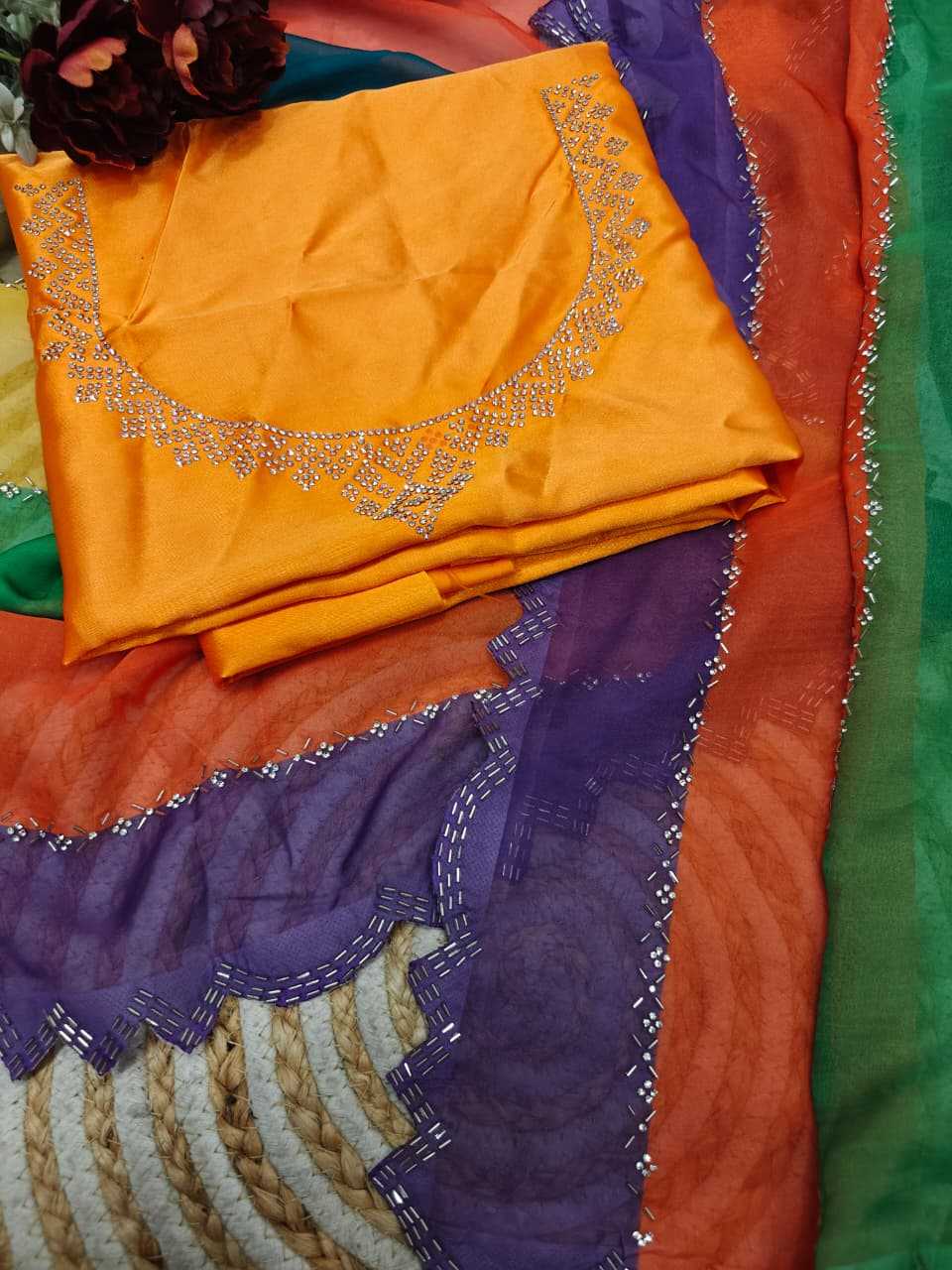 Colorful fabric with orange center piece and purple border on a multicolored background