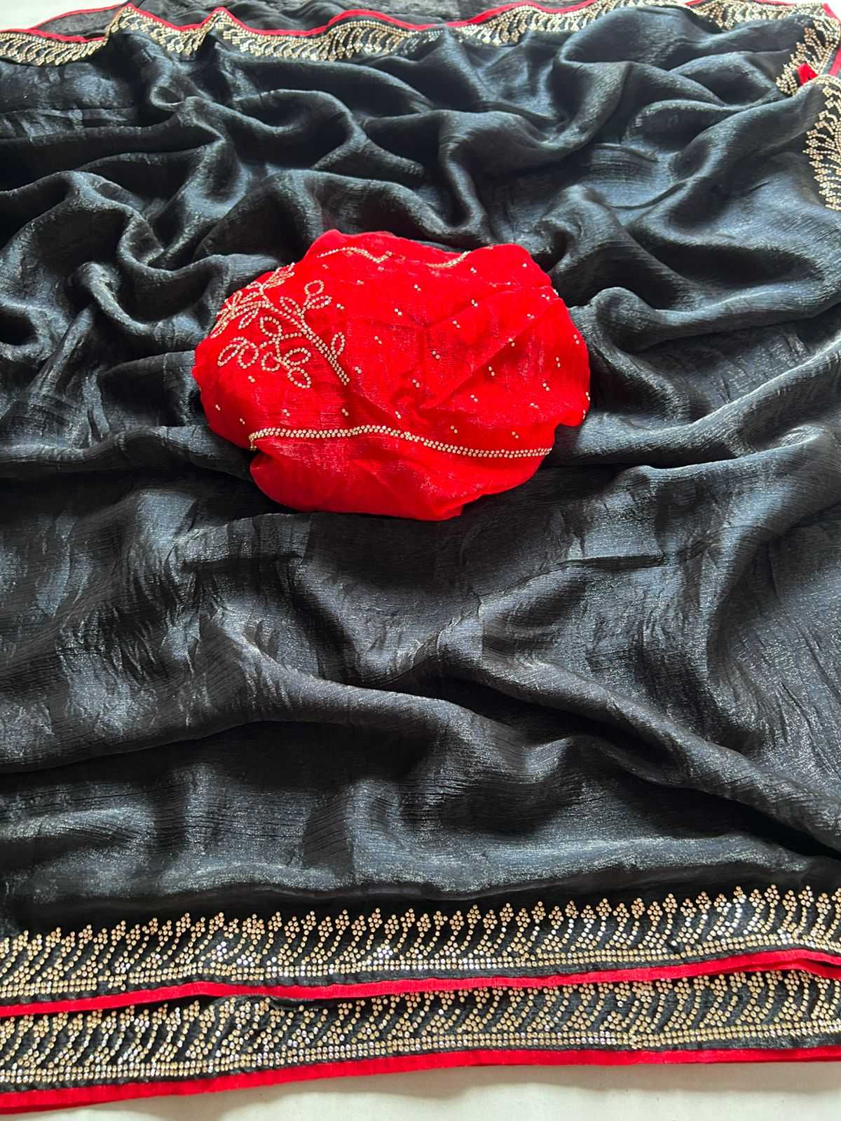 Red embroidered pouch on a black fabric with gold and red border