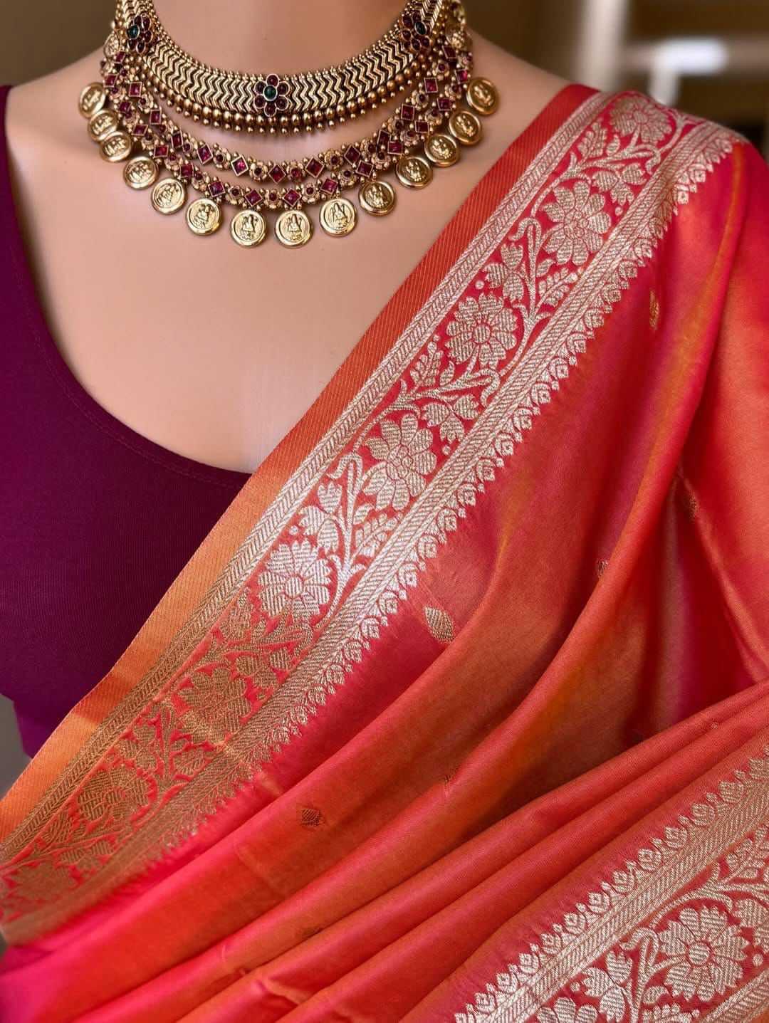 Orange saree with gold border and purple blouse, worn by a mannequin.