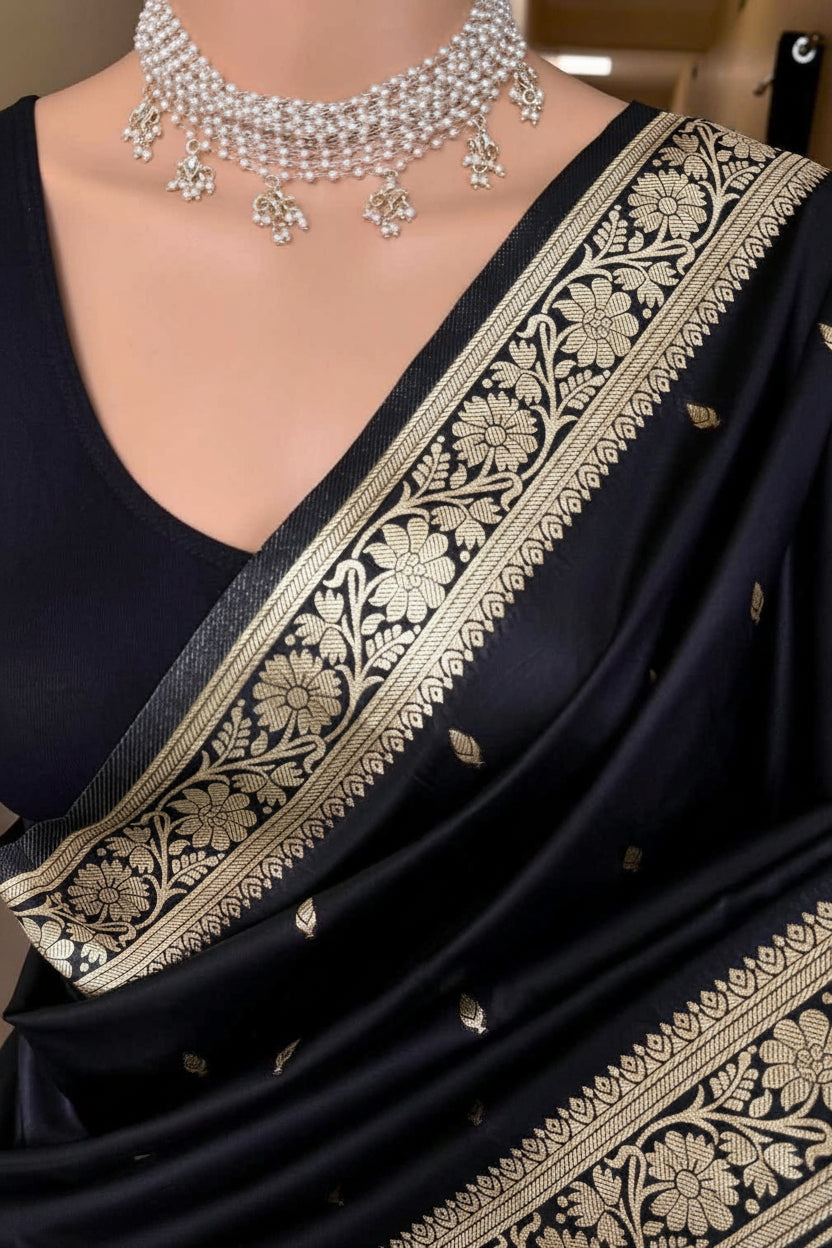 Black saree with gold embroidery and silver necklace on a mannequin