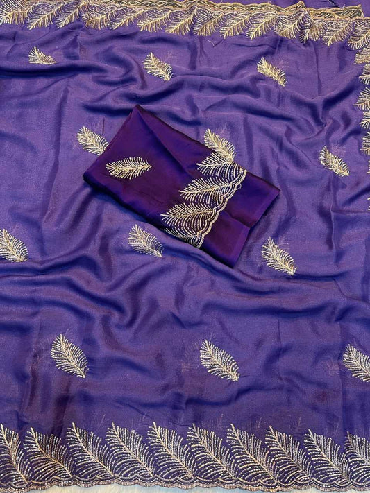 Purple silk-like fabric with gold embroidered leaf motifs and a matching folded fabric piece, laid out on a white background.