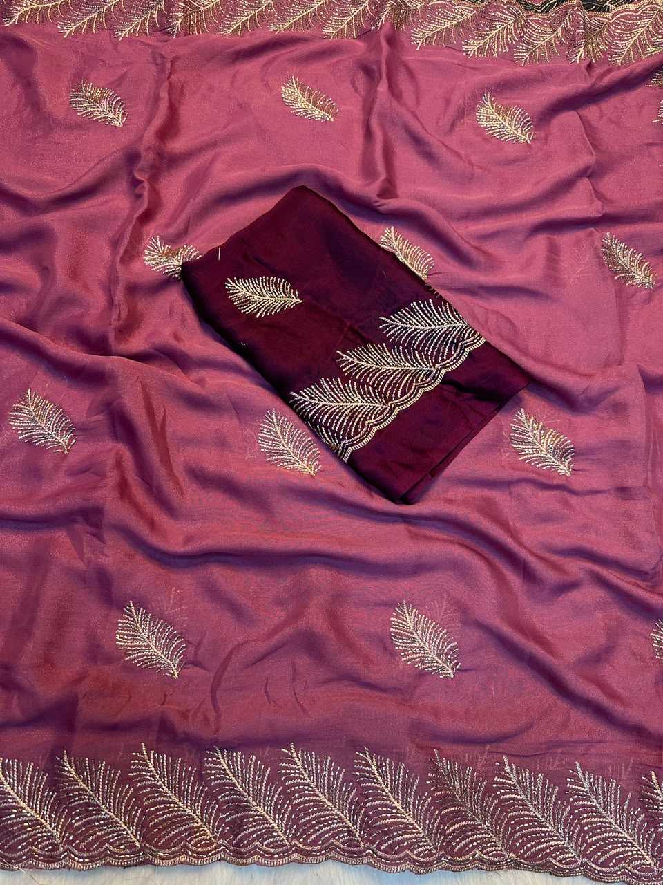 A dusty rose pink silk saree with gold embroidered leaf patterns and a matching dark maroon fabric piece with gold embroidery, laid flat.