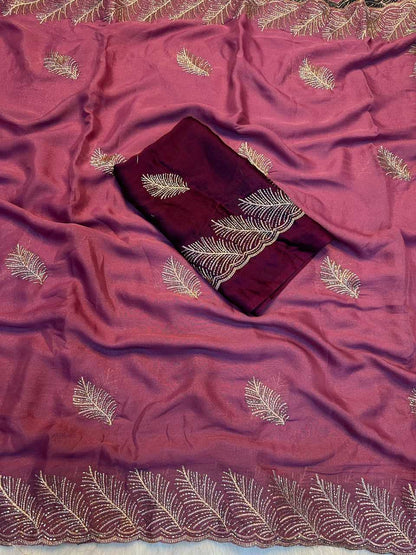A dusty rose pink silk saree with gold embroidered leaf patterns and a matching dark maroon fabric piece with gold embroidery, laid flat.