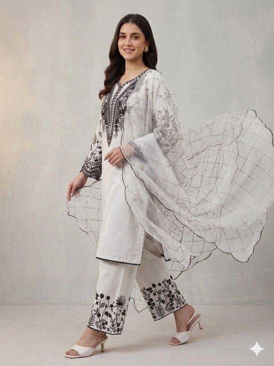 Woman wearing a white and black traditional outfit with a flowing shawl on a gray background