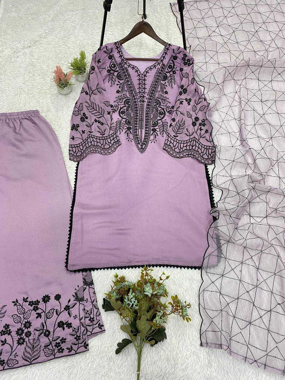 Purple embroidered top and pants set on a textured surface with floral decorations.