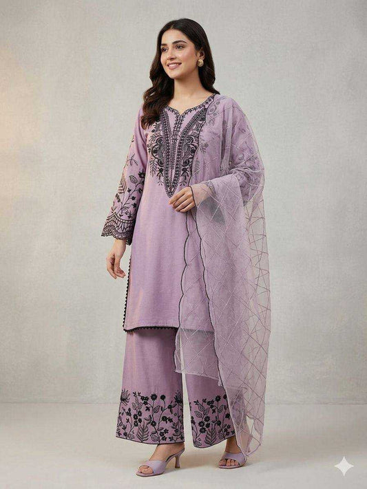 Woman wearing a light purple embroidered outfit with a sheer dupatta on a gray background