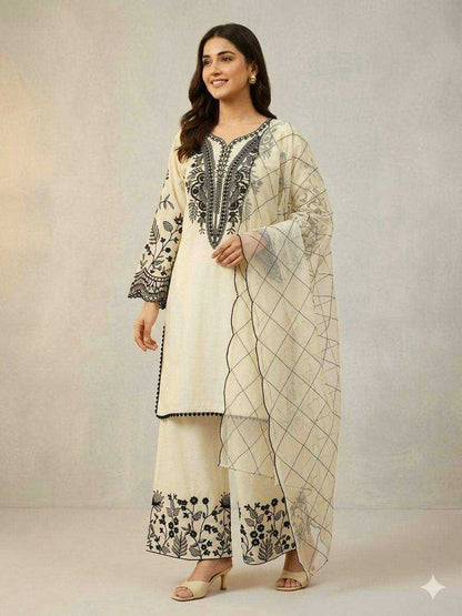 Woman wearing a traditional outfit with embroidered design on a plain background