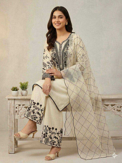 Woman wearing a traditional outfit with floral patterns sitting on a wooden bench.