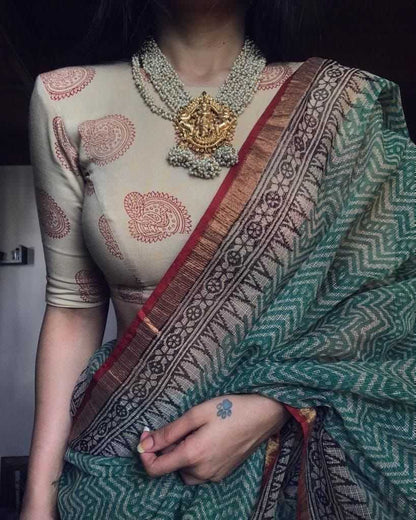 Person wearing a traditional saree with intricate patterns and jewelry.