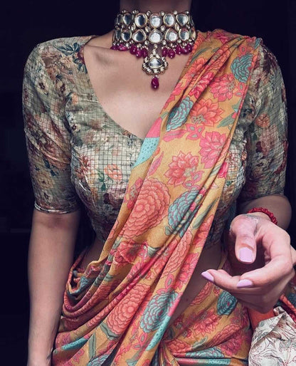 Woman wearing a colorful saree with intricate jewelry against a dark background