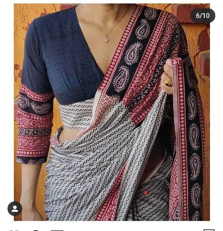 Saree with a blue blouse and patterned border against a wooden background